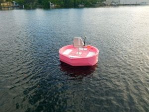 A pink round boat floating in the water