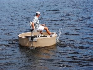 A guy driving a tan round boat with an electric motor