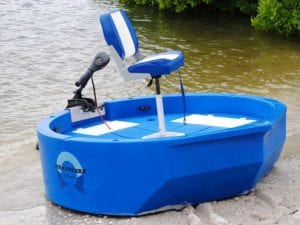 A blue round boat sitting on the shore