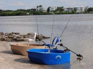 A blue and tan round boat sitting on the shore