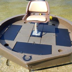 This is a top view of a moss granite colored round boat with white trim sitting on the shore