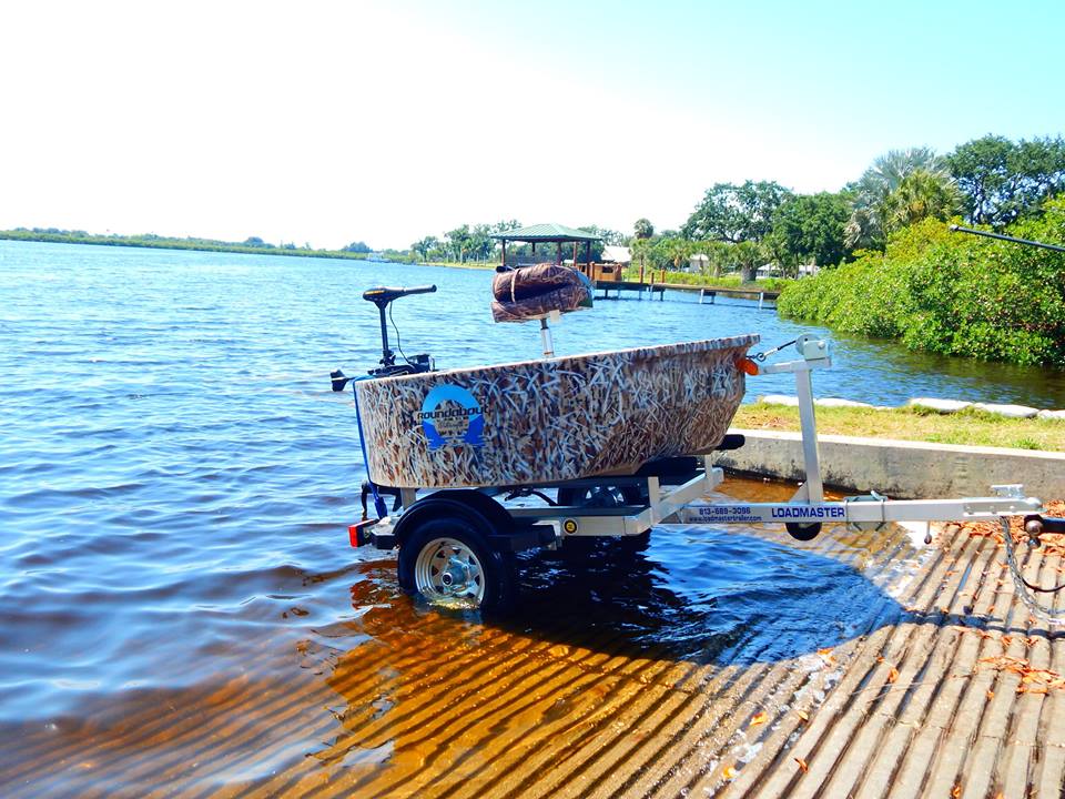 This is the woodsman hunting boat at a boat ramp sitting on a trailer.