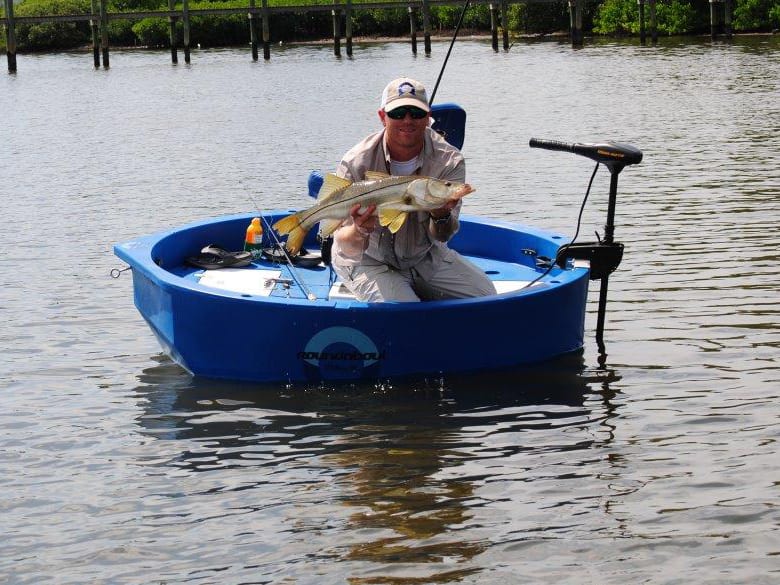 Angler with a freshly caught snook in a round boat