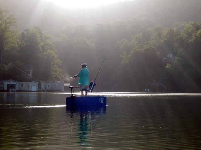 Angler casting a fishing rod from the deck of the round boat
