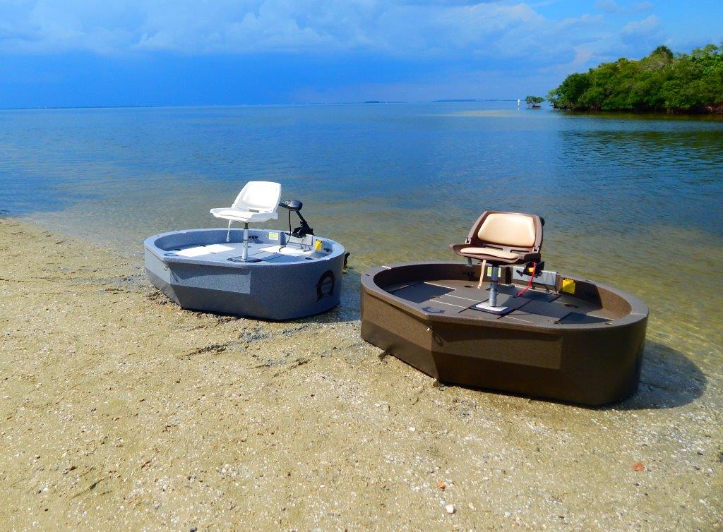 two roundabout watercrafts, the ultraskiff alternative, sitting on the shoreline. One is blue, one is a brown color.